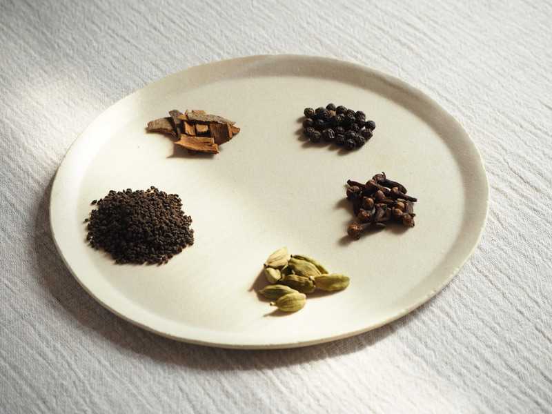 画像: マサラチャイの材料。左から時計回りに、茶葉、シナモン、ブラックペッパー、クローブ、カルダモン